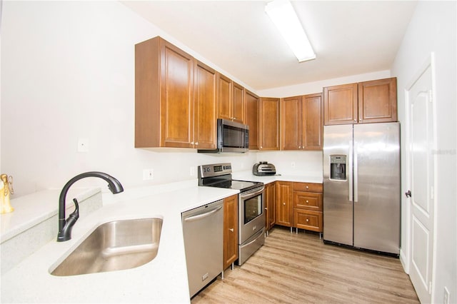 kitchen featuring sink, stainless steel appliances, and light hardwood / wood-style flooring