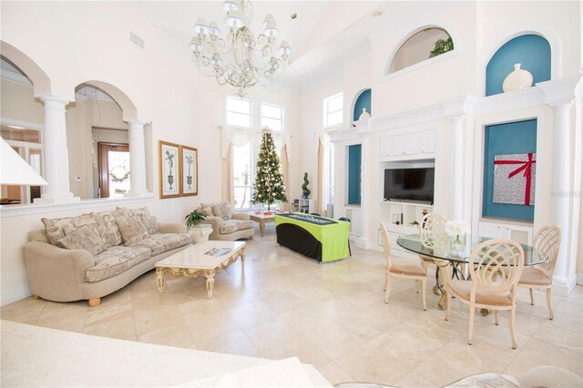 interior space with ornate columns, a high ceiling, and a notable chandelier