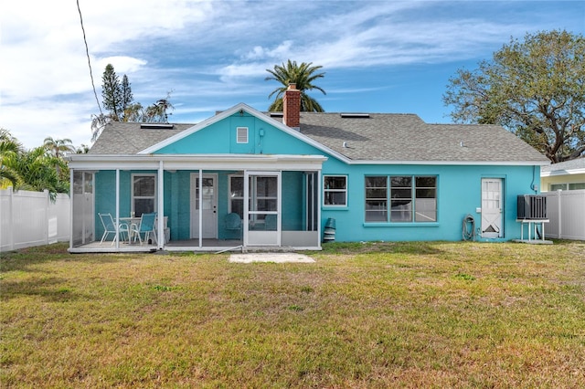 back of property with central air condition unit, a sunroom, a yard, and a patio