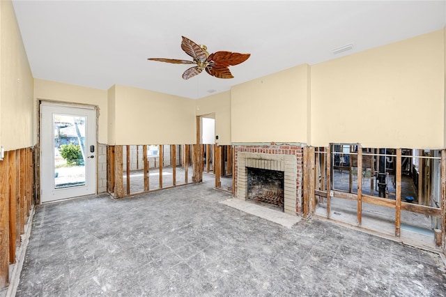 unfurnished living room with ceiling fan and a fireplace