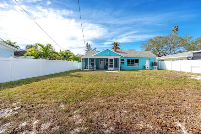 back of property featuring a yard and a sunroom