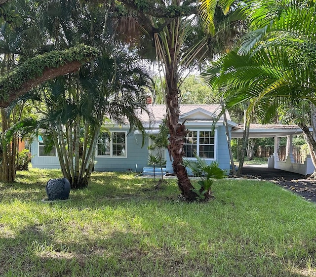 exterior space featuring a front lawn and a carport