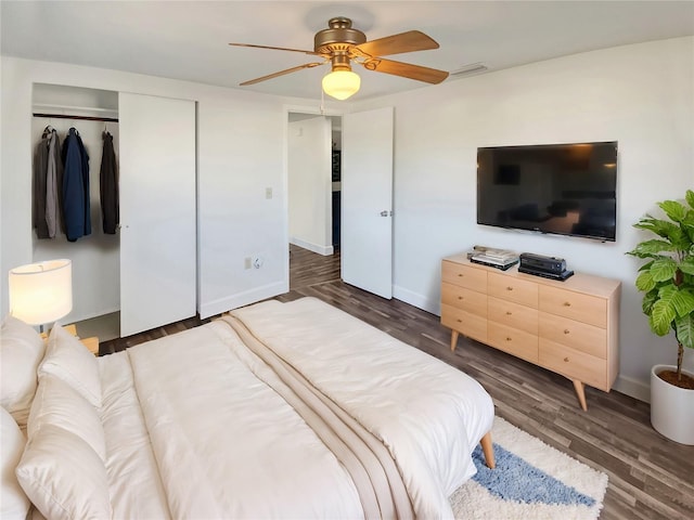 bedroom with ceiling fan, a closet, and dark wood-type flooring