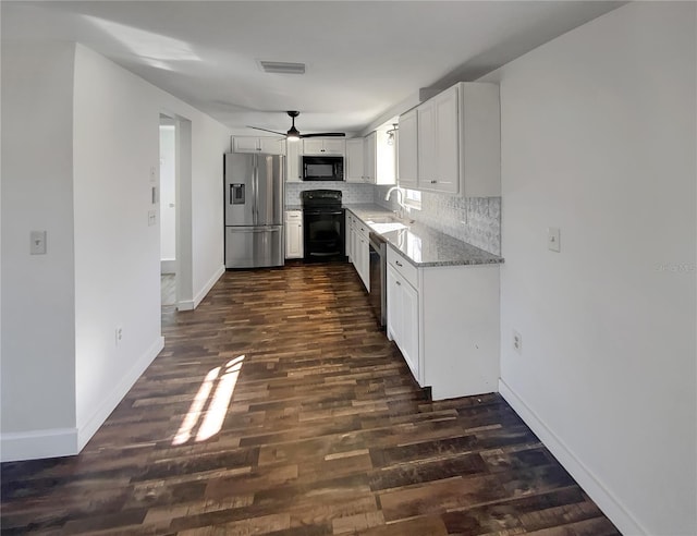 kitchen featuring light stone counters, sink, black appliances, white cabinets, and dark hardwood / wood-style floors