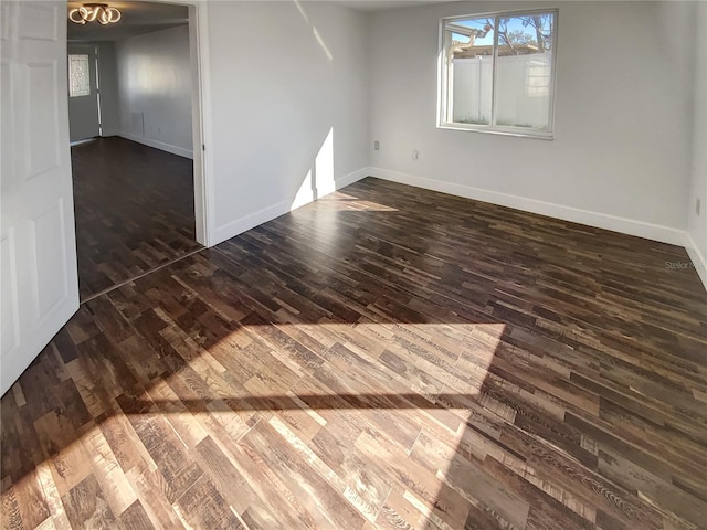 unfurnished room with dark hardwood / wood-style flooring