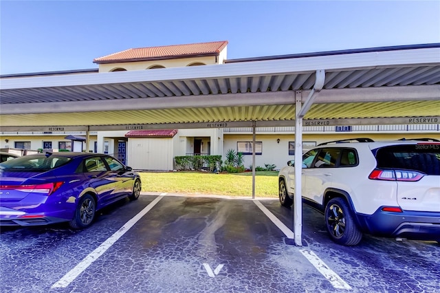 view of parking / parking lot featuring a carport and a yard