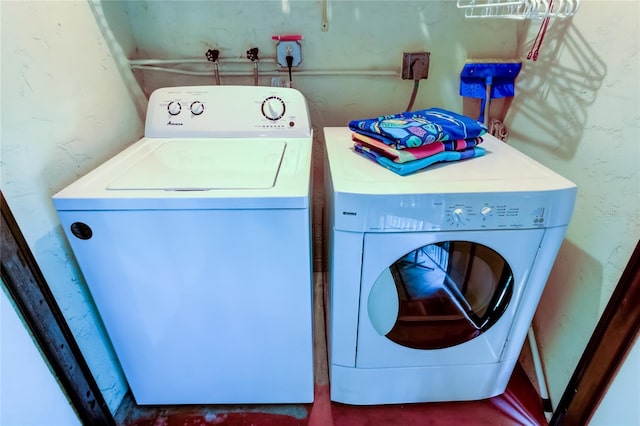 laundry room with laundry area, a textured wall, and independent washer and dryer