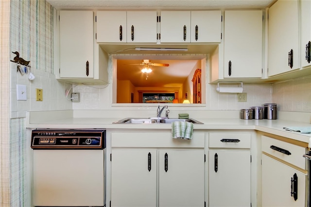 kitchen featuring white dishwasher, white cabinets, sink, decorative backsplash, and ceiling fan