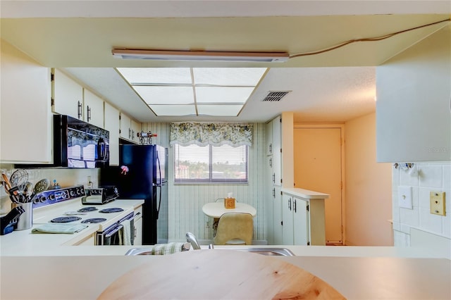 kitchen with black appliances, decorative backsplash, white cabinets, and sink