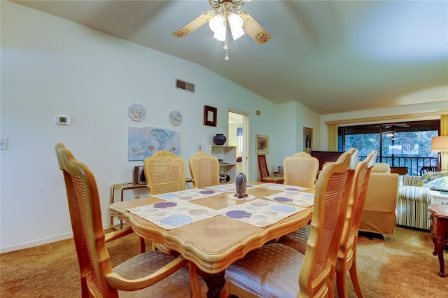 dining area featuring ceiling fan, light colored carpet, and vaulted ceiling