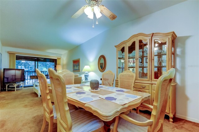 carpeted dining space with vaulted ceiling and ceiling fan