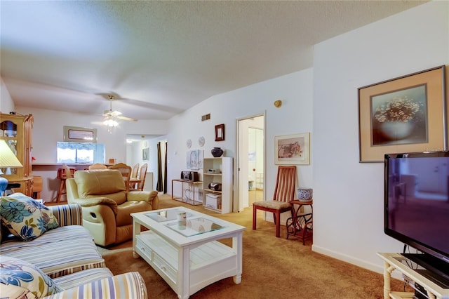 living room featuring carpet flooring, a textured ceiling, and ceiling fan