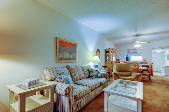 carpeted living room featuring ceiling fan, lofted ceiling, and a textured ceiling