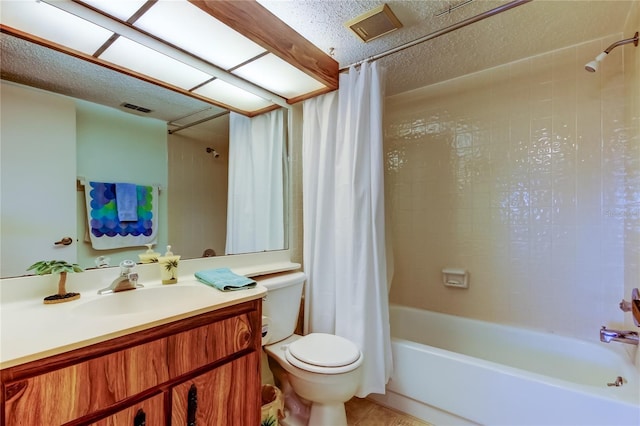 full bathroom with tile patterned floors, vanity, a textured ceiling, shower / bath combo with shower curtain, and toilet