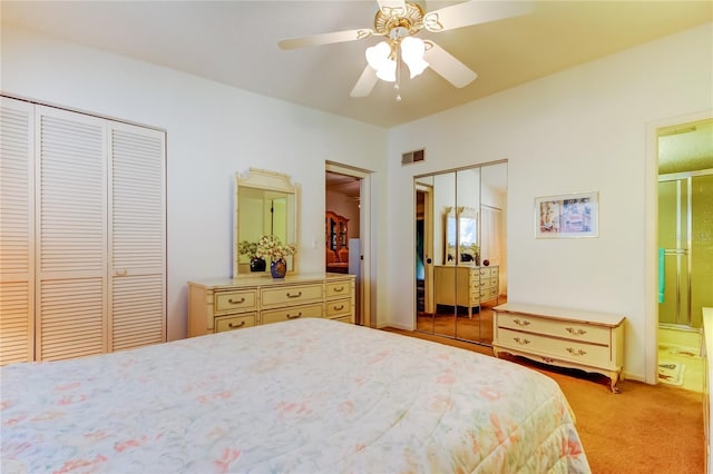 bedroom with visible vents, multiple closets, light carpet, ensuite bathroom, and a ceiling fan