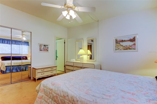 bedroom with a ceiling fan, light colored carpet, and a closet