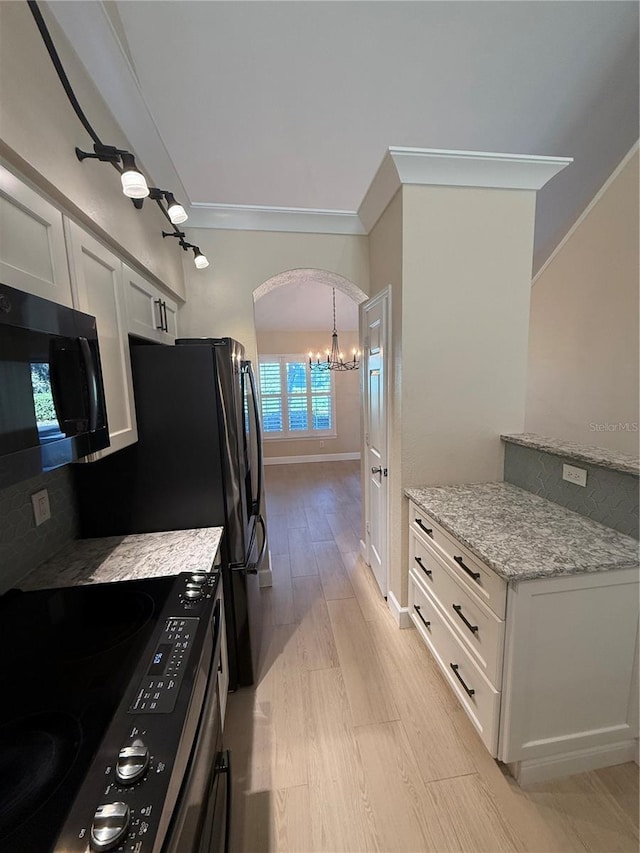 kitchen with white cabinetry, decorative light fixtures, light hardwood / wood-style flooring, range with electric stovetop, and light stone countertops