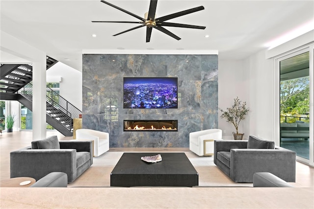 living room with ceiling fan and a fireplace