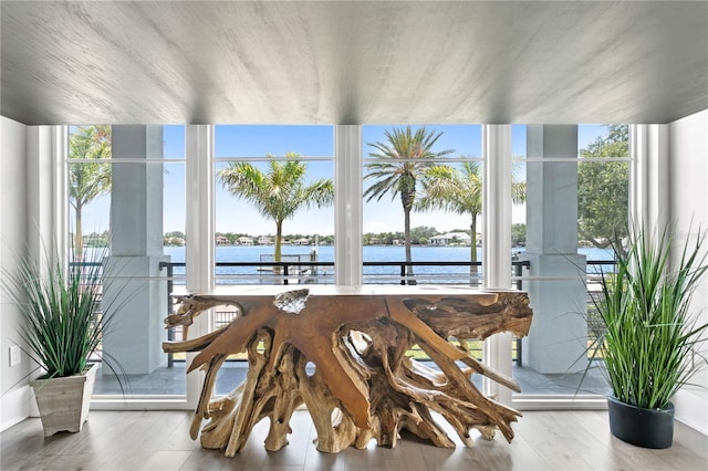 sunroom featuring a water view