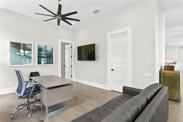 home office with hardwood / wood-style floors and ceiling fan