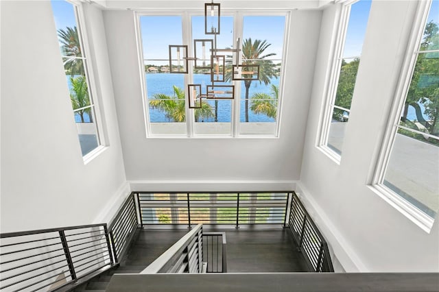 staircase with plenty of natural light and a water view