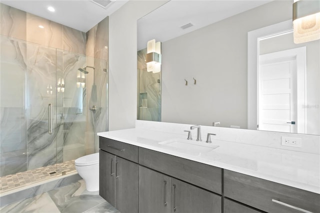 bathroom with a shower with door, vanity, and toilet