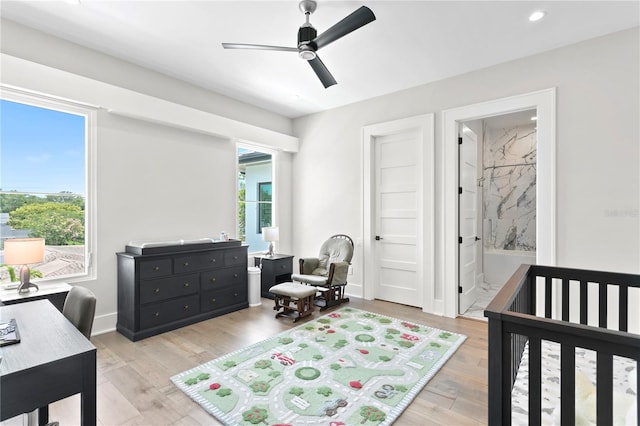 bedroom featuring multiple windows, a nursery area, and ceiling fan