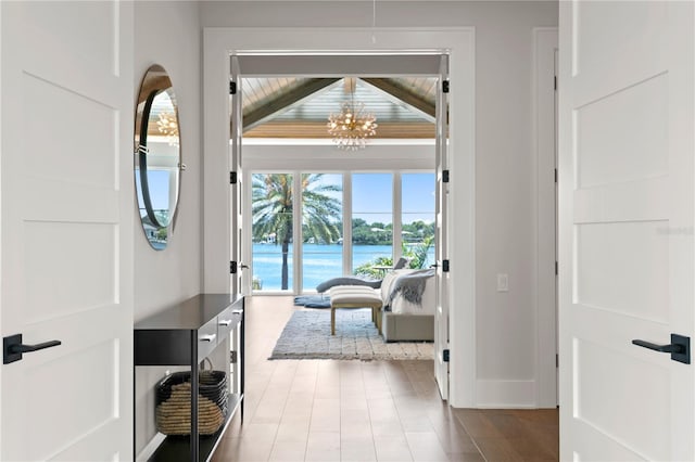 entryway with a water view and a notable chandelier