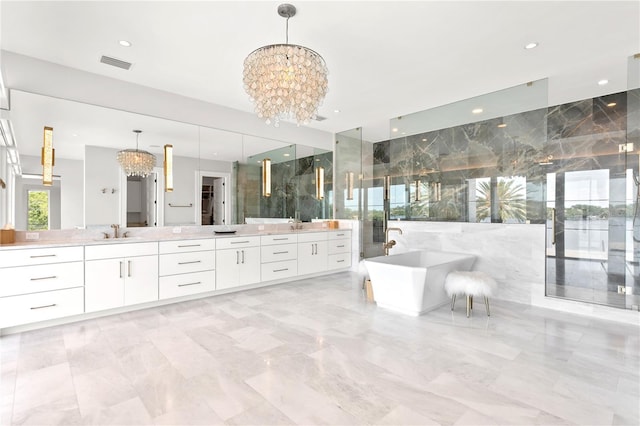 bathroom with a washtub, vanity, an inviting chandelier, and tile walls