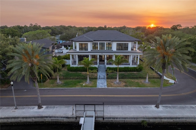 view of front of home featuring a balcony and a yard