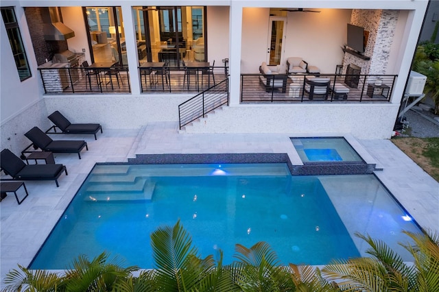 view of swimming pool featuring ceiling fan, a patio area, and an in ground hot tub