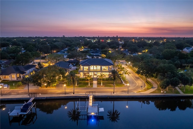 aerial view at dusk featuring a water view