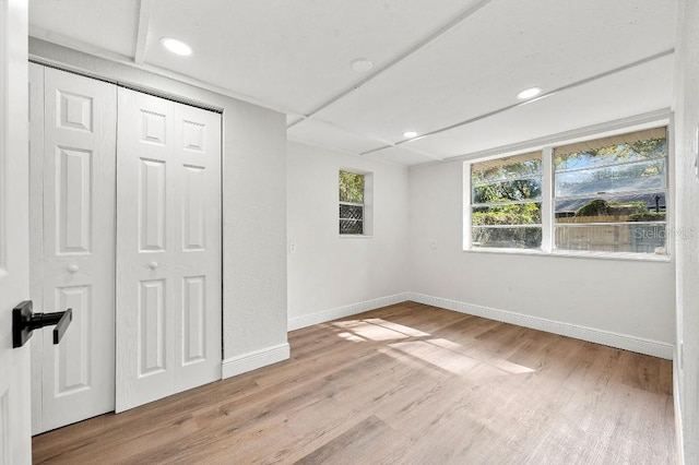 unfurnished bedroom featuring light hardwood / wood-style floors and a closet