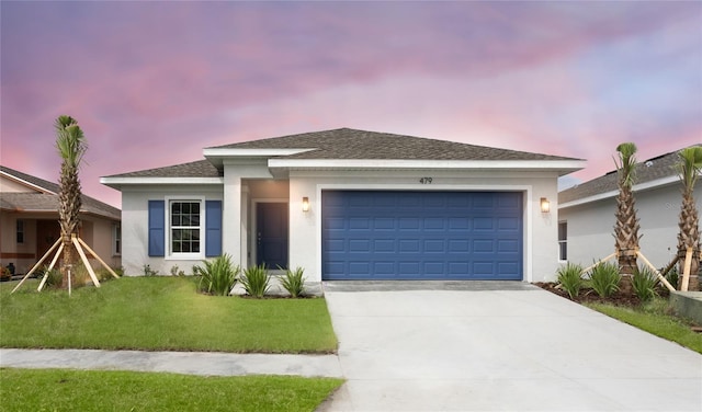 view of front of property featuring a garage and a lawn