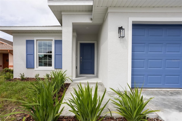 479 Winwood Ct, Port Charlotte, FL 33954 - view of exterior entry with stucco siding, an attached garage, and concrete driveway