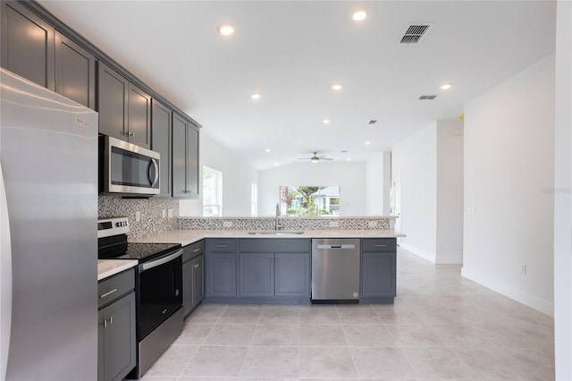 kitchen with lofted ceiling, sink, ceiling fan, kitchen peninsula, and stainless steel appliances