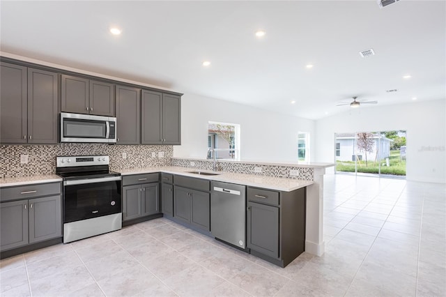 479 Winwood Ct, Port Charlotte, FL 33954 - kitchen featuring appliances with stainless steel finishes, a sink, decorative backsplash, a peninsula, and light countertops