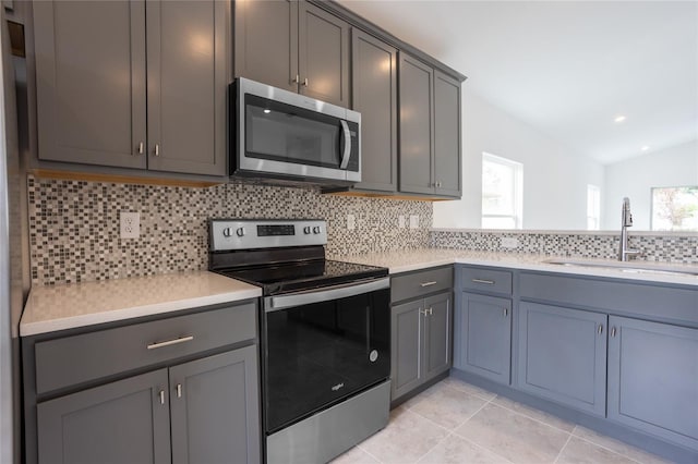 479 Winwood Ct, Port Charlotte, FL 33954 - kitchen with appliances with stainless steel finishes, a sink, gray cabinetry, backsplash, and light countertops