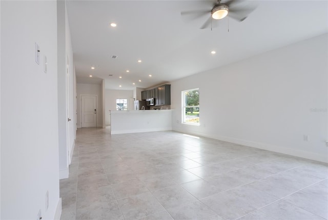 unfurnished living room featuring ceiling fan and light tile patterned floors