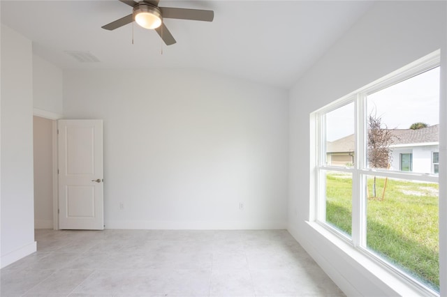 empty room featuring ceiling fan, light tile patterned flooring, and lofted ceiling