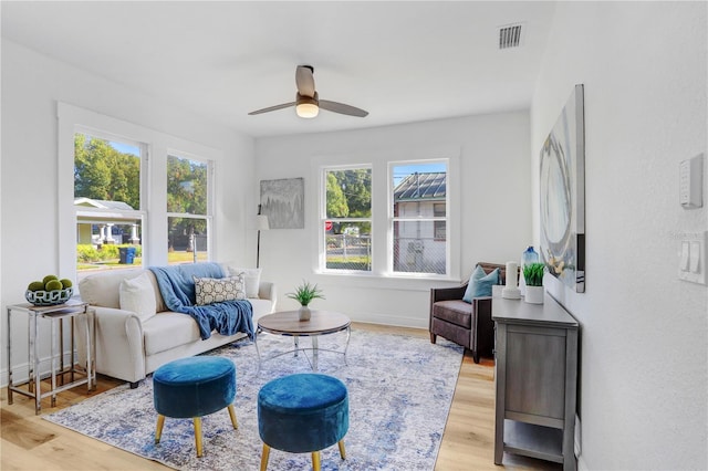 living room featuring ceiling fan, a wealth of natural light, and light hardwood / wood-style floors