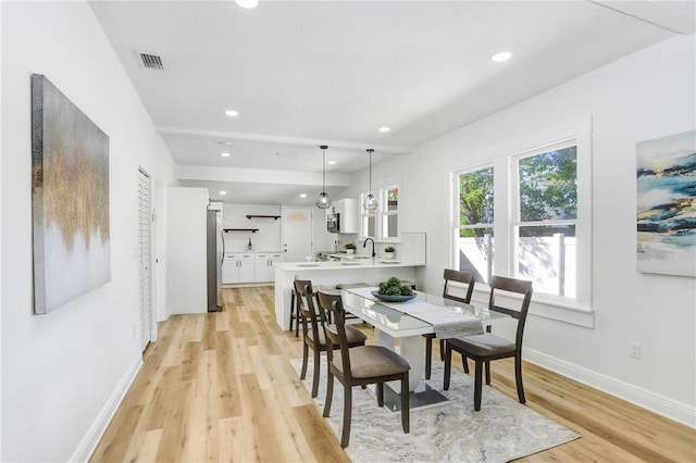 dining area featuring sink and light wood-type flooring