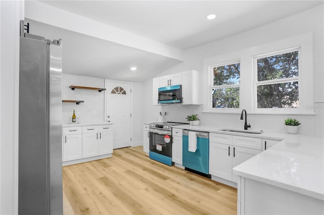 kitchen with sink, decorative backsplash, stainless steel appliances, and white cabinets