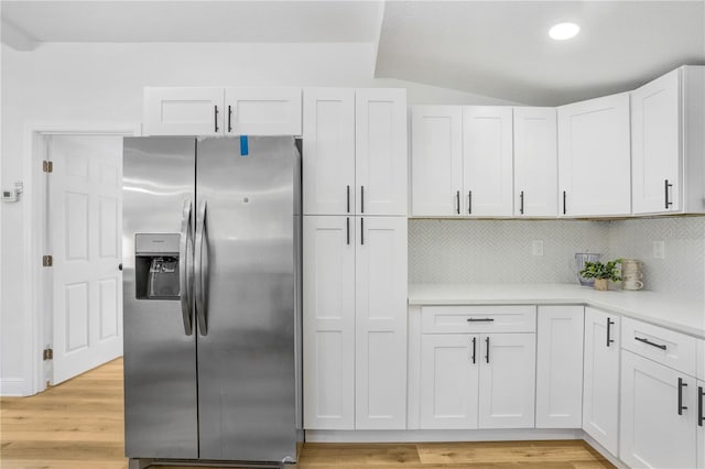 kitchen with white cabinetry, stainless steel fridge with ice dispenser, light hardwood / wood-style flooring, and tasteful backsplash