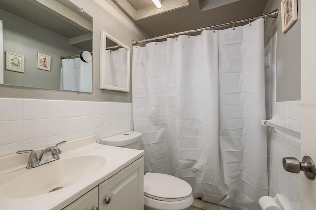 bathroom with walk in shower, vanity, toilet, and tile walls