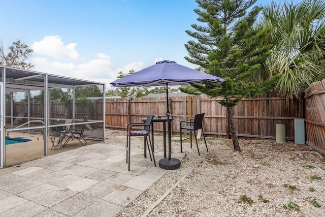 view of patio with a fenced in pool and glass enclosure