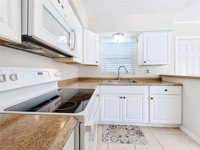 kitchen featuring sink, white cabinets, light tile patterned flooring, and white appliances