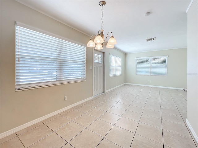 tiled empty room featuring crown molding and a chandelier