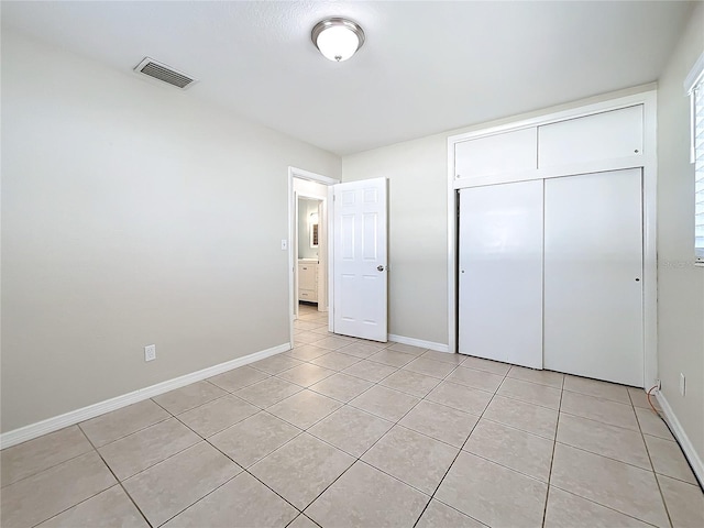 unfurnished bedroom with a closet and light tile patterned flooring