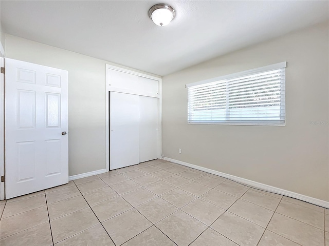 unfurnished bedroom with a closet and light tile patterned floors